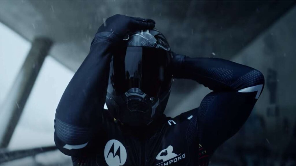 An image of a person sitting on a bench in a track field