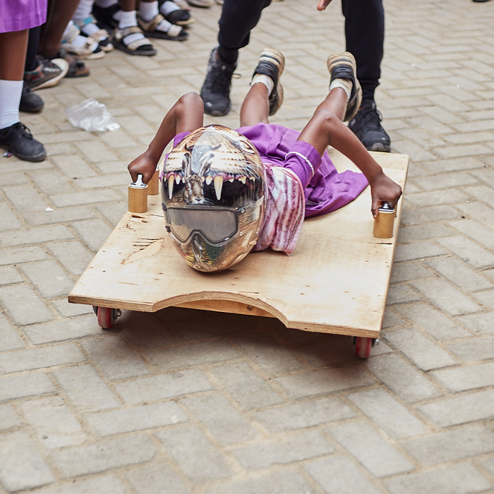 a child playing on a skeleton racing board with a helmet