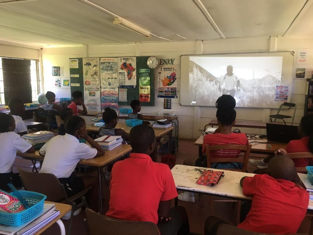a class watching Akwasi Frimpong on video