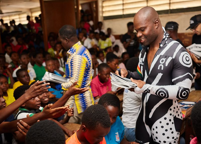 Akwasi distributing Black Ice comics to kids
