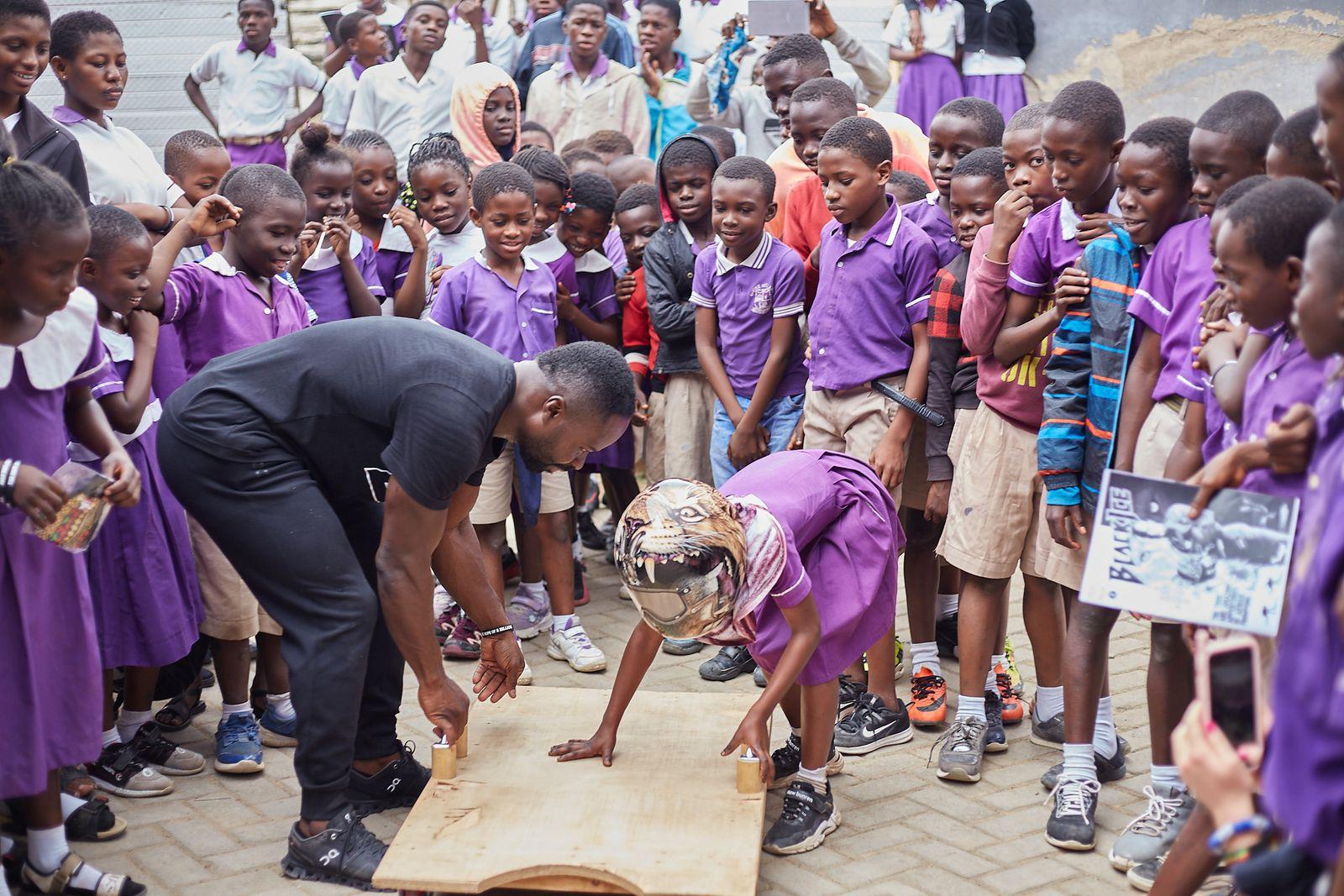 Akwasi Frimpong helping a child get on a board